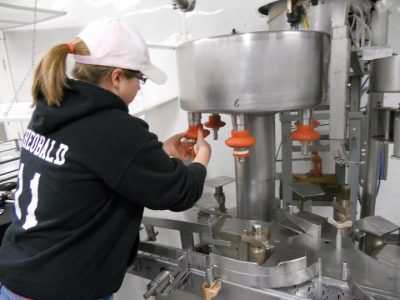 An Creamworks Dairy employee dealing with machinery